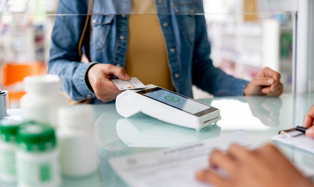 Close-up on a customer making a contactless payment at the pharmacy